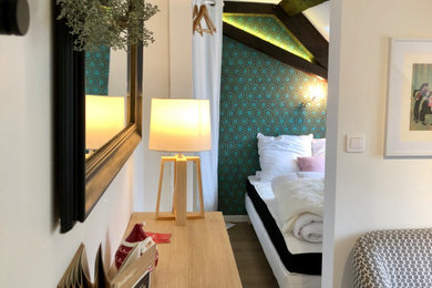 Cette image montre une chambre parentale nordique avec un mur vert, un sol en vinyl, aucune cheminée, un sol marron et du papier peint.