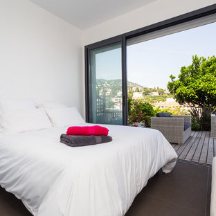 Cette photo montre une chambre parentale tendance de taille moyenne avec un mur blanc et un sol en carrelage de céramique.