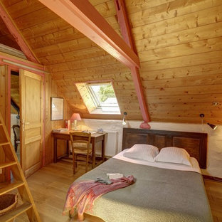 Idée de décoration pour une chambre chalet avec un mur blanc, un sol en bois brun et un sol marron.