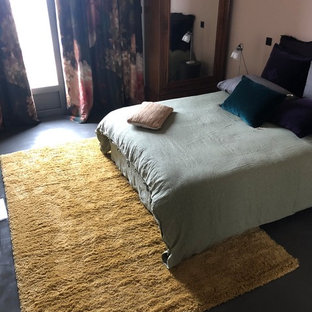 Ejemplo de habitación de invitados ecléctica, grande, sin chimenea, con suelo de cemento, suelo verde y parades naranjas