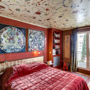Cette image montre une chambre parentale bohème de taille moyenne avec un mur rouge, un sol en bois clair et aucune cheminée.