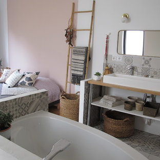 Imagen de dormitorio principal, bohemio, grande, con paredes rosas, suelo de madera clara y suelo multicolor