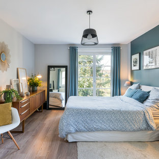 Exemple d'une chambre parentale rétro avec un mur multicolore, un sol en bois foncé et un sol marron.
