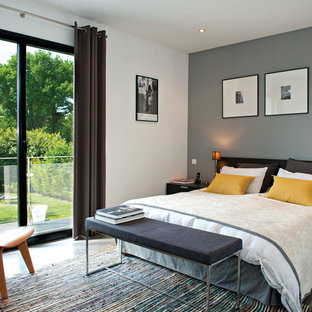 Exemple d'une chambre parentale tendance de taille moyenne avec un mur gris.