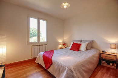 На фото: хозяйская спальня в стиле шебби-шик с белыми стенами и полом из ламината с