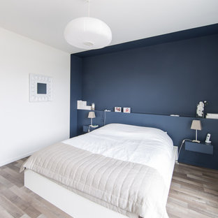 Diseño de dormitorio principal, actual, de tamaño medio, con paredes azules y suelo de madera clara