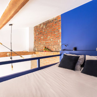 Idées déco pour une petit chambre mansardée ou avec mezzanine industrielle avec un mur bleu, un sol en bois brun et un sol marron.