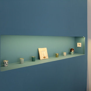 Foto de dormitorio principal, minimalista, pequeño, sin chimenea, con paredes azules, suelo laminado y suelo marrón