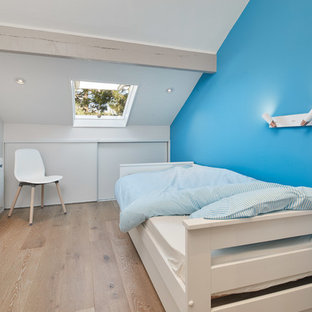 Idées déco pour une chambre bord de mer avec un mur bleu, un sol en bois brun et un sol marron.