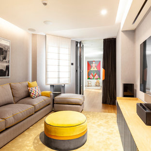Imagen de cine en casa cerrado, contemporáneo, con paredes grises, suelo de madera en tonos medios y pantalla de proyección