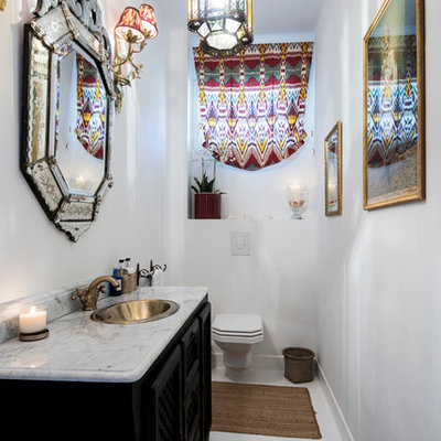 Inspiration for a mediterranean powder room remodel in London with furniture-like cabinets, black cabinets, a wall-mount toilet, white walls and a drop-in sink