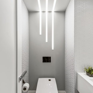 Design ideas for a contemporary cloakroom in West Midlands with a wall mounted toilet, porcelain flooring, white worktops, multi-coloured walls and white floors.