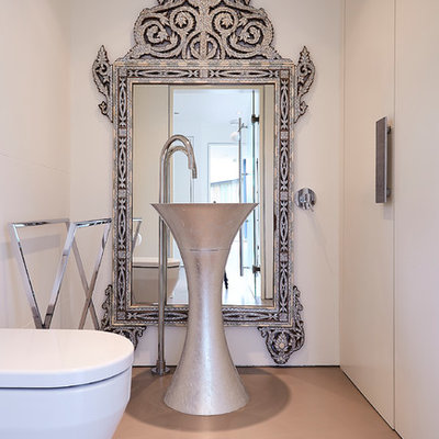 Inspiration for a mid-sized mediterranean orange floor powder room remodel in London with flat-panel cabinets, white cabinets, a wall-mount toilet and white walls
