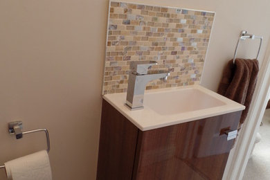 他の地域にある小さなモダンスタイルのおしゃれなトイレ・洗面所 (フラットパネル扉のキャビネット、ベージュの壁、セラミックタイルの床、モザイクタイル) の写真