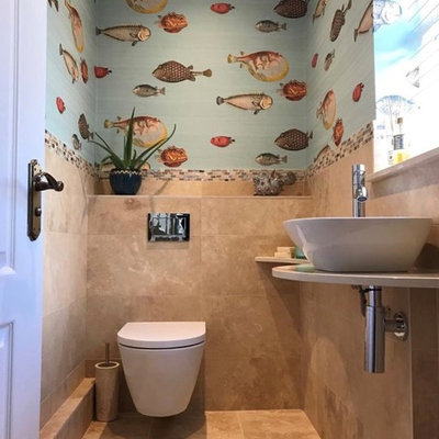 Powder room - mediterranean travertine floor powder room idea in Other with a wall-mount toilet and quartz countertops