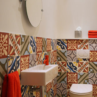 Réalisation d'un petit WC et toilettes méditerranéen avec un lavabo suspendu, un carrelage multicolore, un mur multicolore, un sol en carrelage de porcelaine et un WC à poser.