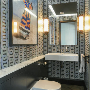 Inspiration for a contemporary cloakroom in London with a wall mounted toilet, multi-coloured walls, medium hardwood flooring, a wall-mounted sink and brown floors.