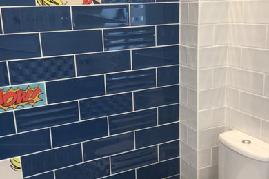 Идея дизайна: туалет в стиле модернизм с унитазом-моноблоком, синей плиткой, керамической плиткой и синими стенами