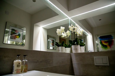 Photo of a small contemporary cloakroom in Other with glass-front cabinets, white cabinets, a wall mounted toilet, grey tiles, porcelain tiles, grey walls, porcelain flooring, a wall-mounted sink and grey floors.