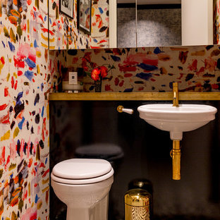 Design ideas for a small eclectic cloakroom in London with black cabinets, a one-piece toilet, multi-coloured tiles, multi-coloured walls, ceramic flooring, a wall-mounted sink, wooden worktops, black floors and black worktops.