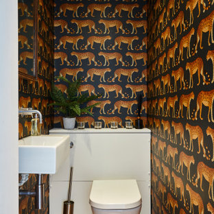 Design ideas for a contemporary cloakroom in Surrey with multi-coloured walls, medium hardwood flooring, a wall-mounted sink and brown floors.
