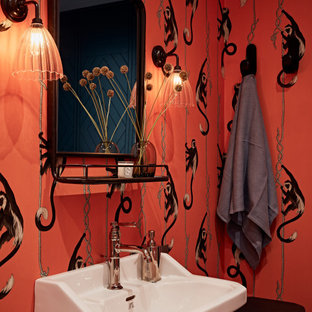 This is an example of a classic cloakroom in London with a freestanding vanity unit, wallpapered walls, multi-coloured walls, a pedestal sink and white worktops.