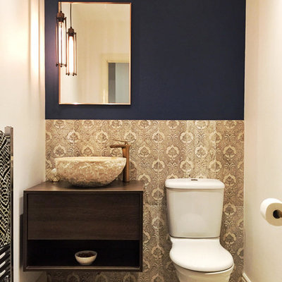 Inspiration for a small mediterranean powder room remodel in Other with flat-panel cabinets, dark wood cabinets, a one-piece toilet, blue walls and brown countertops