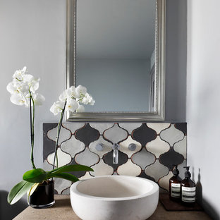 Cette photo montre un petit WC et toilettes méditerranéen avec des carreaux de céramique, un mur gris, un plan de toilette en béton, un placard en trompe-l'oeil, des portes de placard grises, un carrelage gris, une vasque et un plan de toilette beige.
