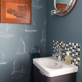 Small beach style cloakroom in Sussex with flat-panel cabinets, grey cabinets, blue tiles, white tiles, blue walls, an integrated sink and white worktops.