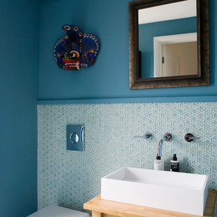 This is an example of a contemporary cloakroom in Other with a one-piece toilet, blue tiles, white tiles, matchstick tiles, blue walls, a vessel sink and wooden worktops.
