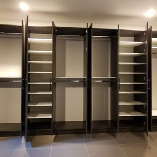 Esempio di un ampio spazio per vestirsi unisex moderno con ante lisce, ante in legno bruno, pavimento in gres porcellanato e pavimento beige