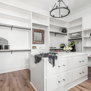 Idéer för att renovera ett stort lantligt walk-in-closet för könsneutrala, med släta luckor, vita skåp, ljust trägolv och flerfärgat golv
