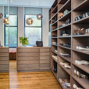 Dressing room - large contemporary gender-neutral dark wood floor and brown floor dressing room idea in New York with flat-panel cabinets and medium tone wood cabinets