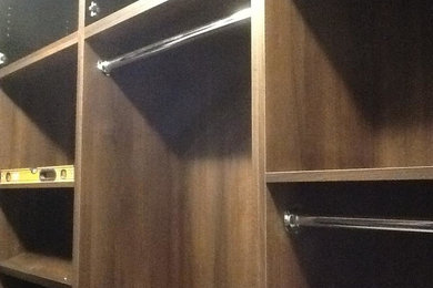 Foto de armario vestidor unisex clásico de tamaño medio con armarios con paneles empotrados y puertas de armario de madera en tonos medios