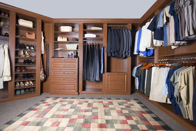Foto de armario vestidor unisex clásico grande con armarios con paneles con relieve, puertas de armario de madera en tonos medios, moqueta y suelo gris