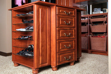 Diseño de armario vestidor unisex clásico de tamaño medio con armarios con paneles con relieve, puertas de armario de madera en tonos medios, moqueta y suelo beige