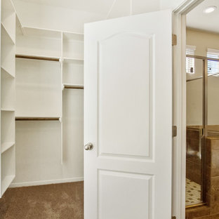 Ispirazione per una cabina armadio unisex mediterranea di medie dimensioni con moquette e pavimento beige
