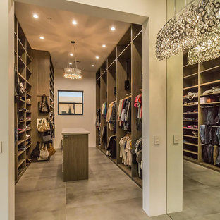 Imagen de armario vestidor unisex, contemporáneo, grande, con armarios con paneles lisos, puertas de armario de madera clara y suelo de cemento