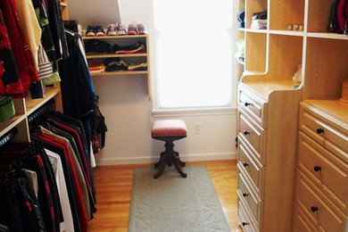 This is an example of a gender neutral wardrobe in New York with light wood cabinets and light hardwood flooring.