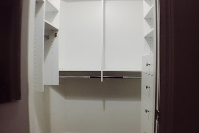 Example of a minimalist walk-in closet design in Montreal with white cabinets