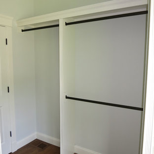 Esempio di una grande cabina armadio unisex chic con ante bianche e parquet chiaro
