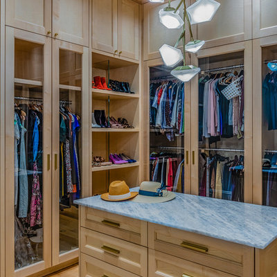 Walk-in closet - transitional women's medium tone wood floor and brown floor walk-in closet idea in Boston with glass-front cabinets and light wood cabinets