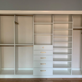 Ispirazione per un piccolo armadio o armadio a muro unisex classico con ante lisce, ante bianche, parquet chiaro e pavimento giallo