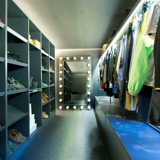 Aménagement d'un grand dressing industriel neutre avec un placard sans porte, des portes de placard grises et un sol noir.