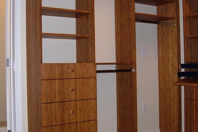 Imagen de armario vestidor unisex contemporáneo grande con armarios con paneles lisos, puertas de armario de madera oscura y moqueta