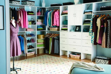 Example of a mid-sized trendy women's light wood floor walk-in closet design in Philadelphia with white cabinets
