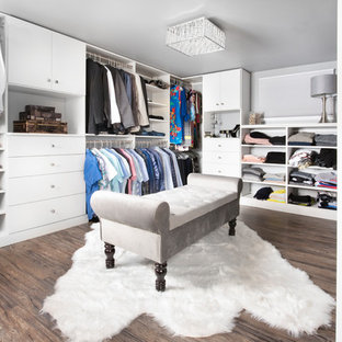 Idee per una grande cabina armadio unisex classica con ante lisce, ante bianche, pavimento in vinile e pavimento marrone