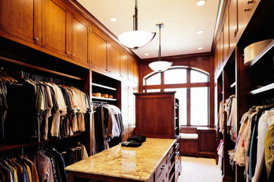 Example of a large gender-neutral carpeted walk-in closet design in Cincinnati with medium tone wood cabinets