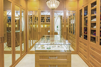 Inspiration for a mid-sized transitional gender-neutral carpeted walk-in closet remodel in Los Angeles with recessed-panel cabinets and medium tone wood cabinets