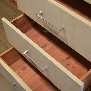 Idee per una piccola cabina armadio unisex stile marino con ante lisce, ante in legno chiaro e pavimento in legno massello medio